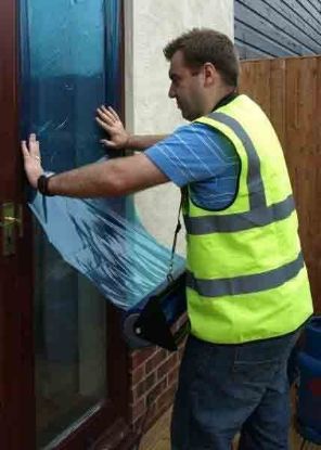 man applying a window protection film
